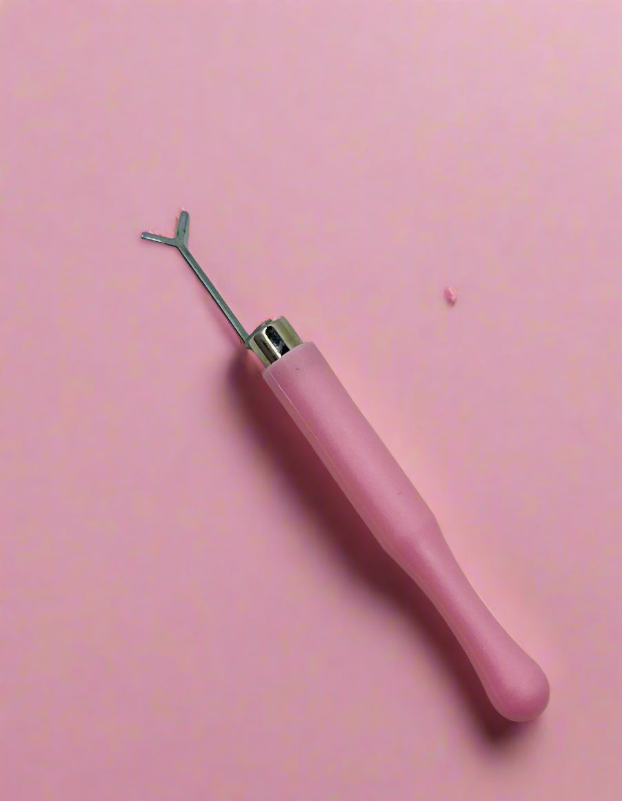 Pink-handled tool with a metallic tip on a white background